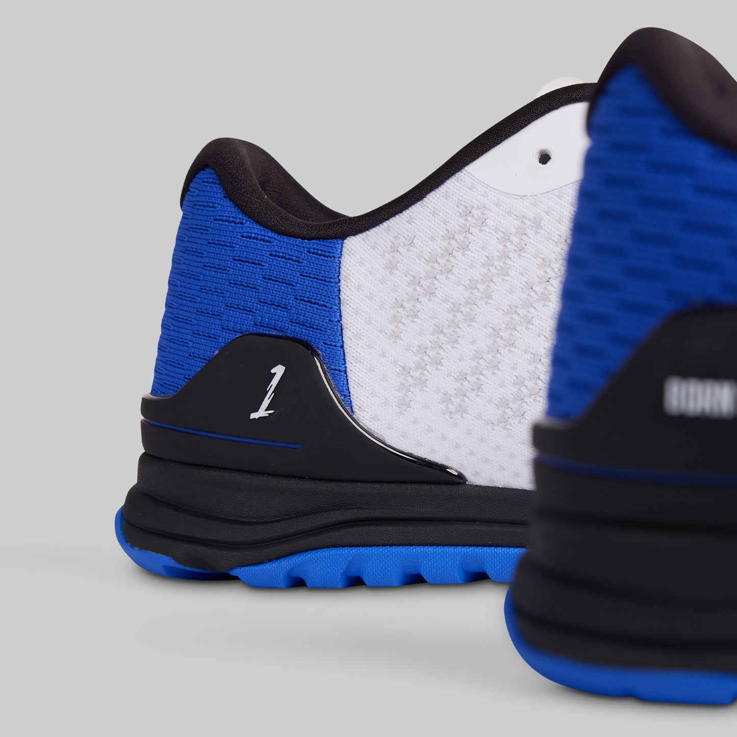 Blue and black athletic shoe with white sole on a gray background