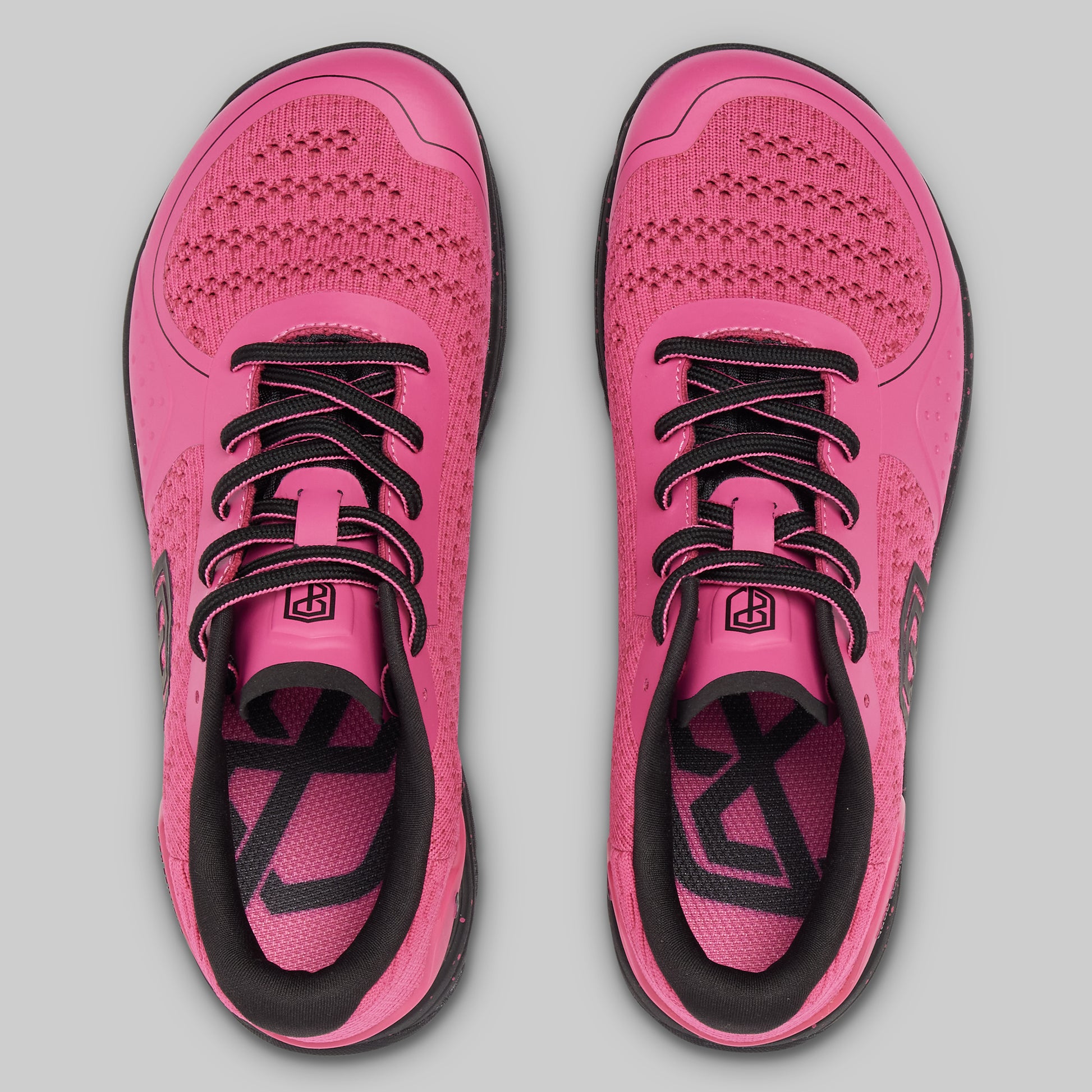 Pair of pink running shoes with black accents on a gray background