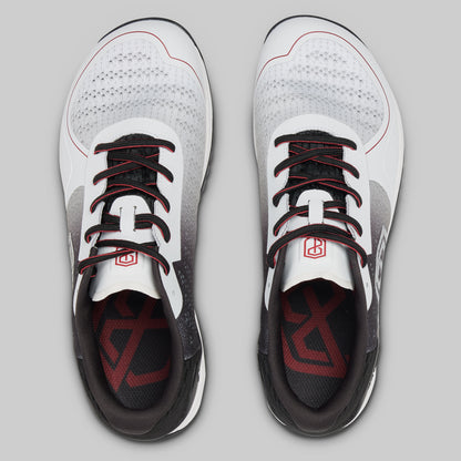 White athletic shoes with black and red accents on a gray background