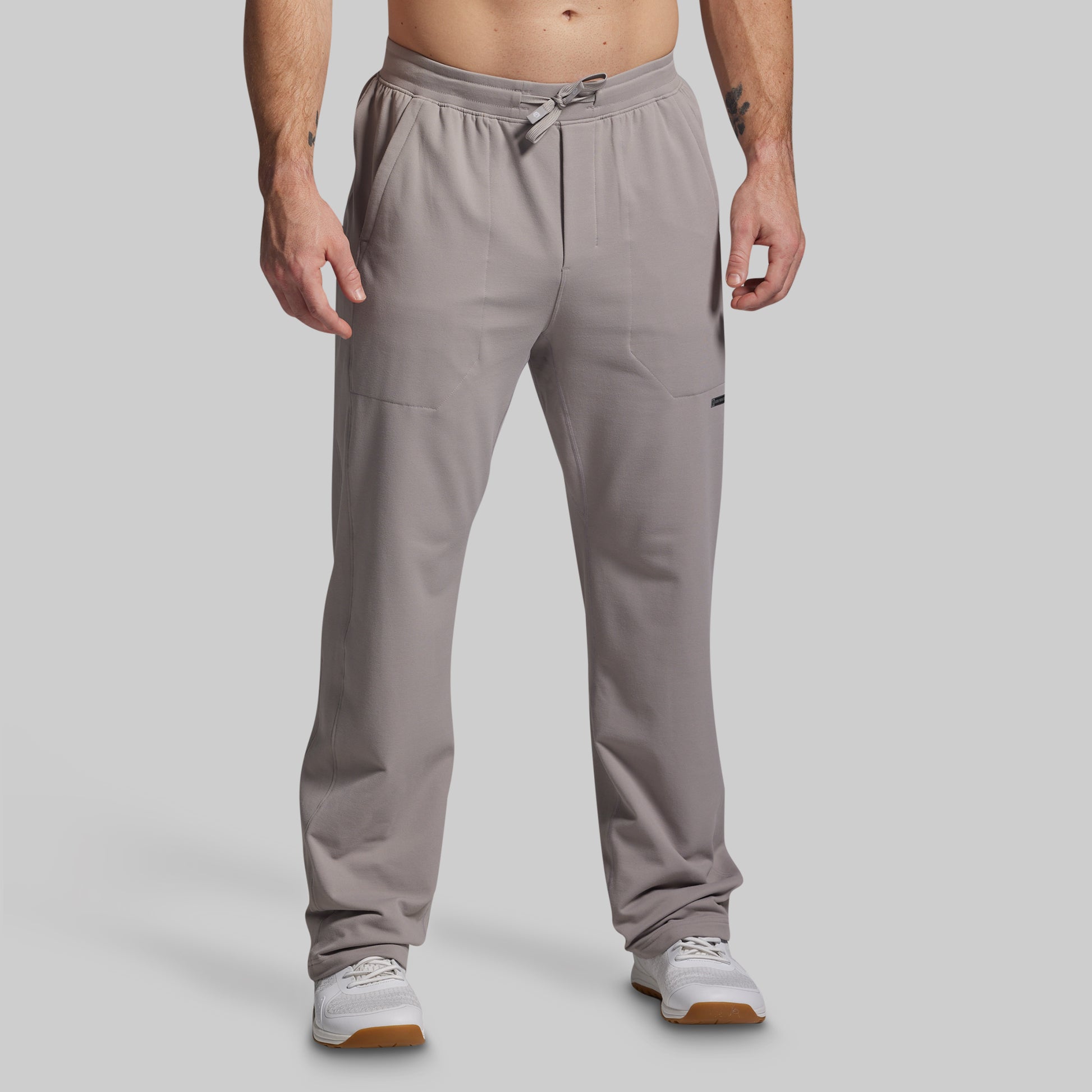 Man wearing gray pants on a plain background