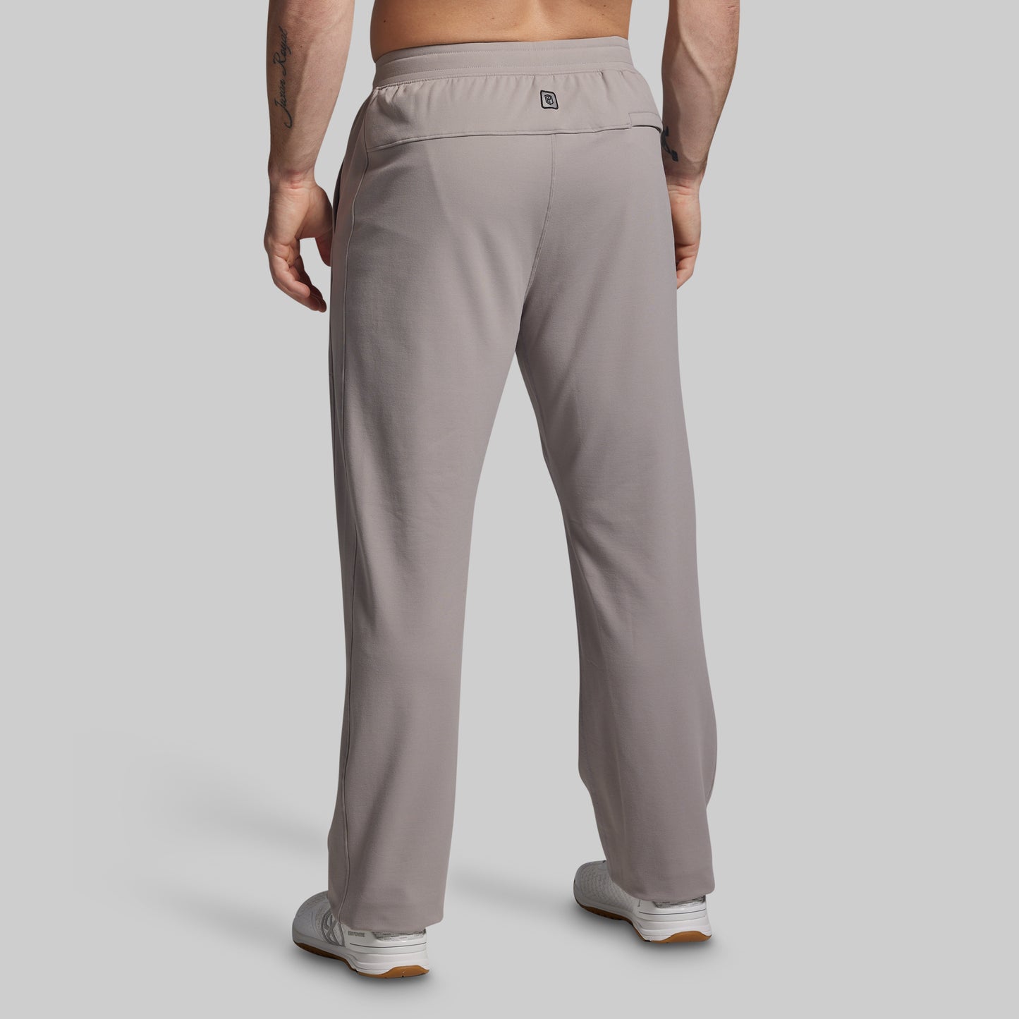 Person wearing grey pants on a plain background
