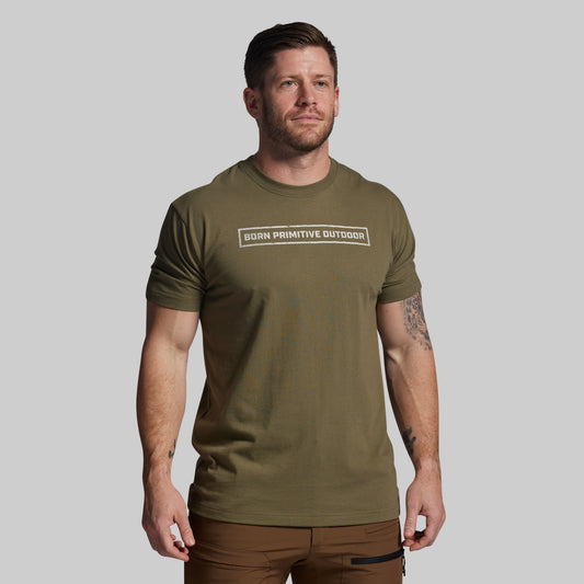Man wearing an olive green t-shirt with text on a plain background