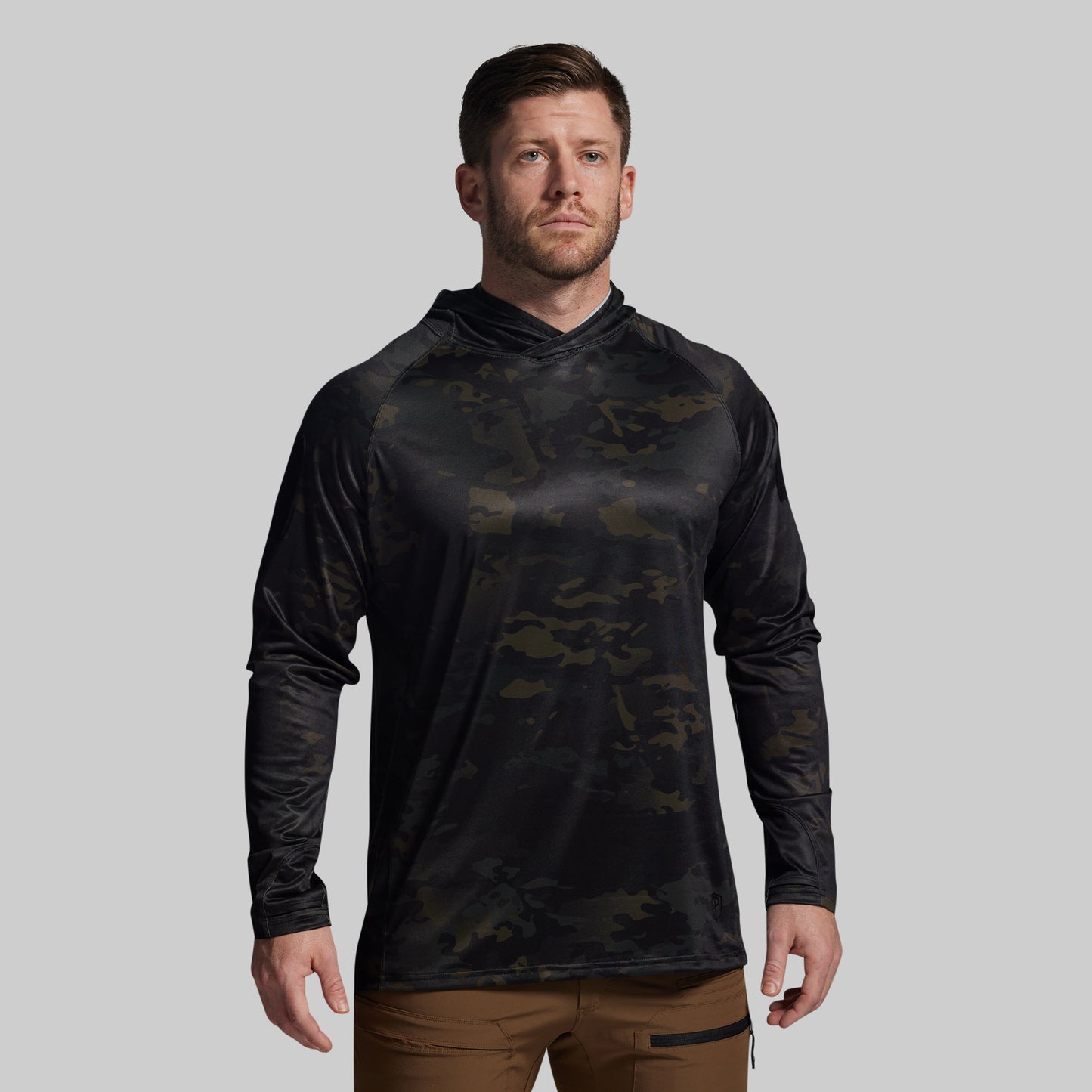 Man wearing a black camouflage long-sleeve shirt on a gray background