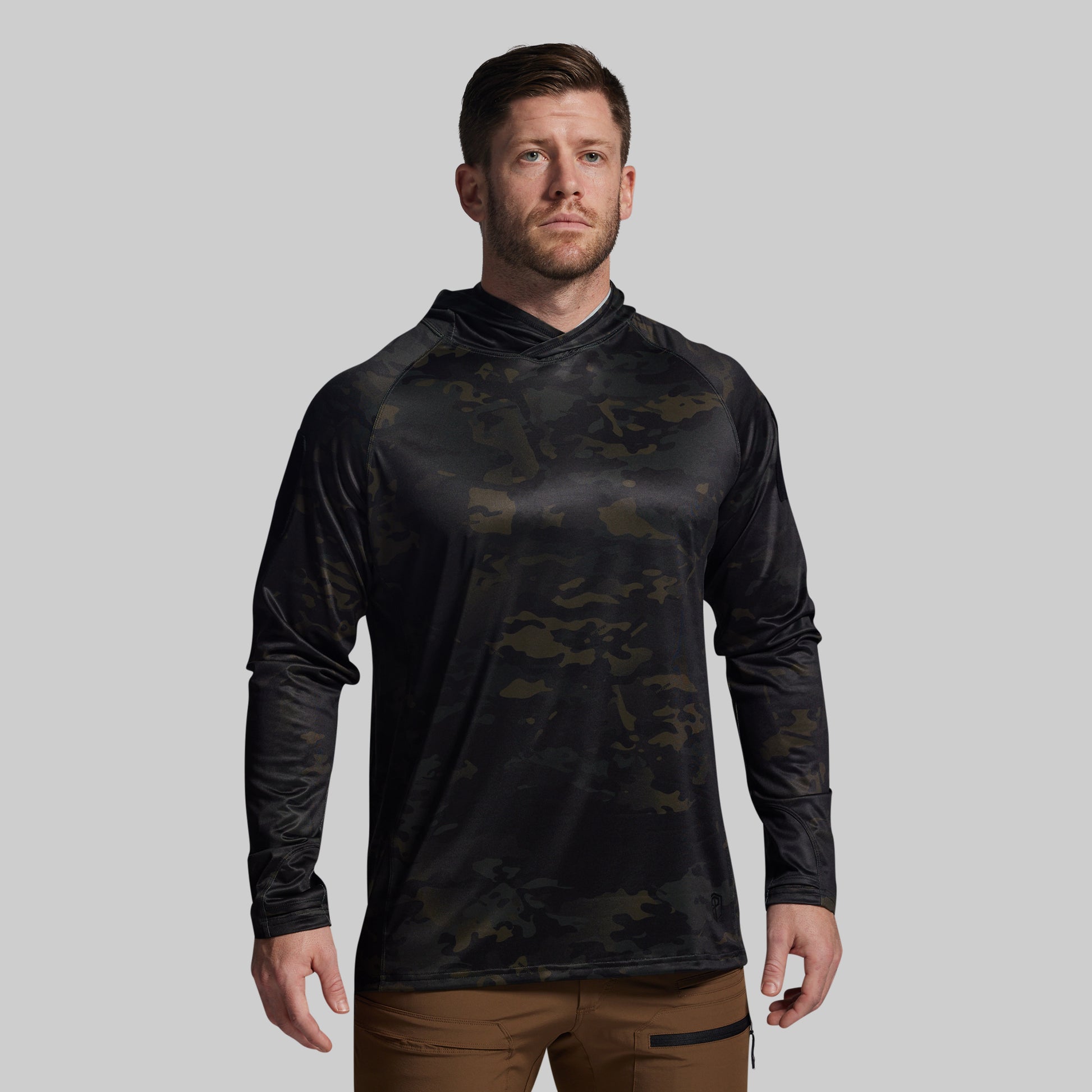 Man wearing a black camouflage long-sleeve shirt on a gray background