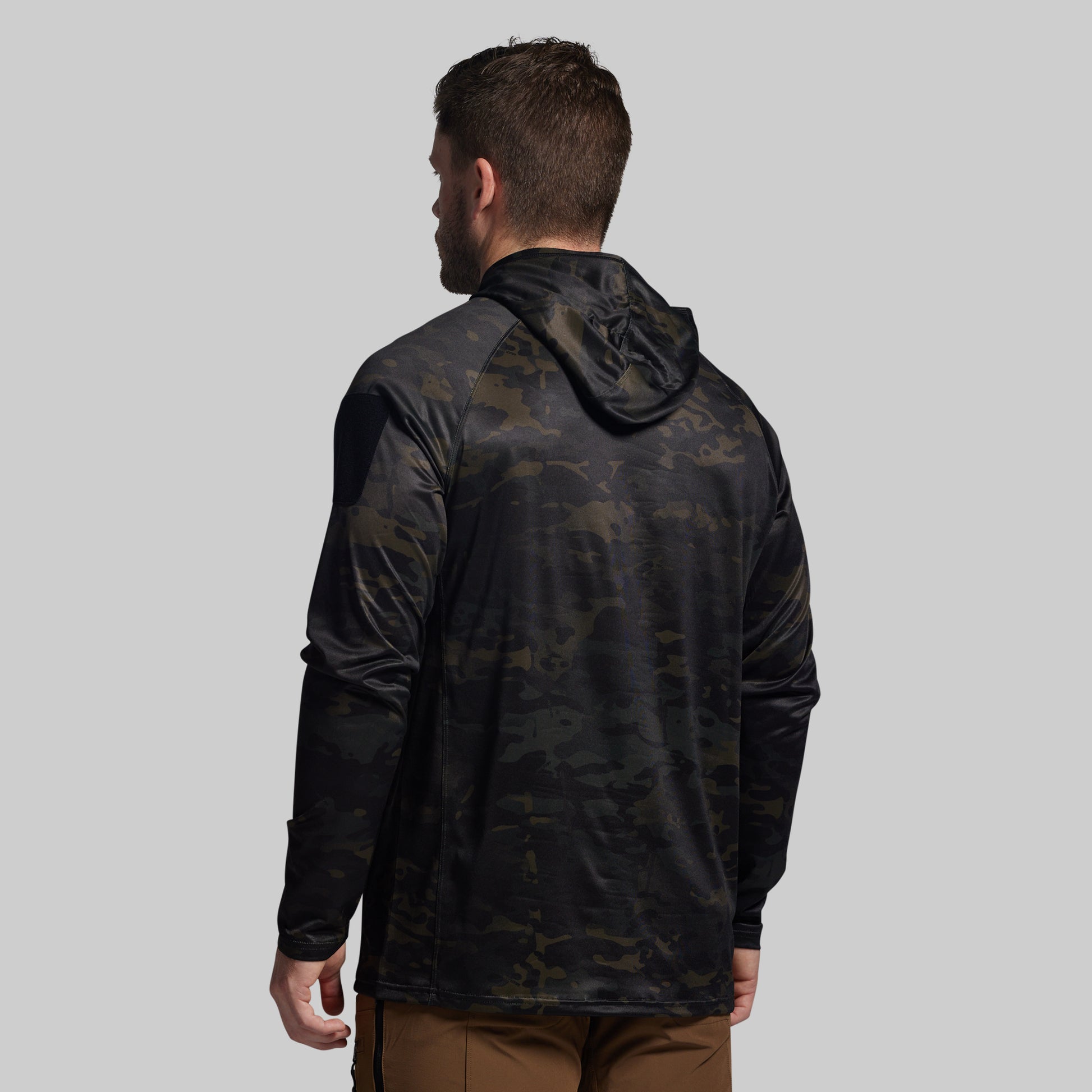 Man wearing a black camouflage sun shirt on a gray background