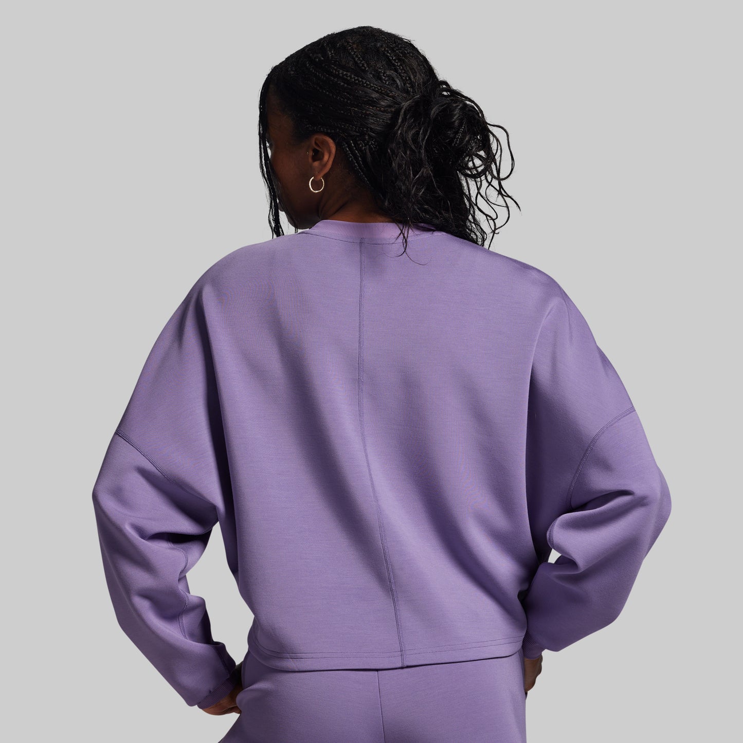 Person wearing a purple outfit against a gray background
