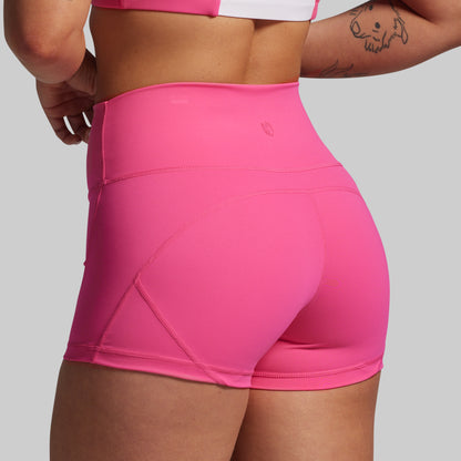 Person wearing bright pink athletic shorts on a light gray background