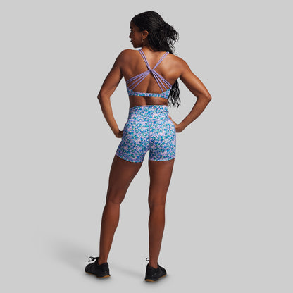 Woman wearing a floral sports outfit on a gray background
