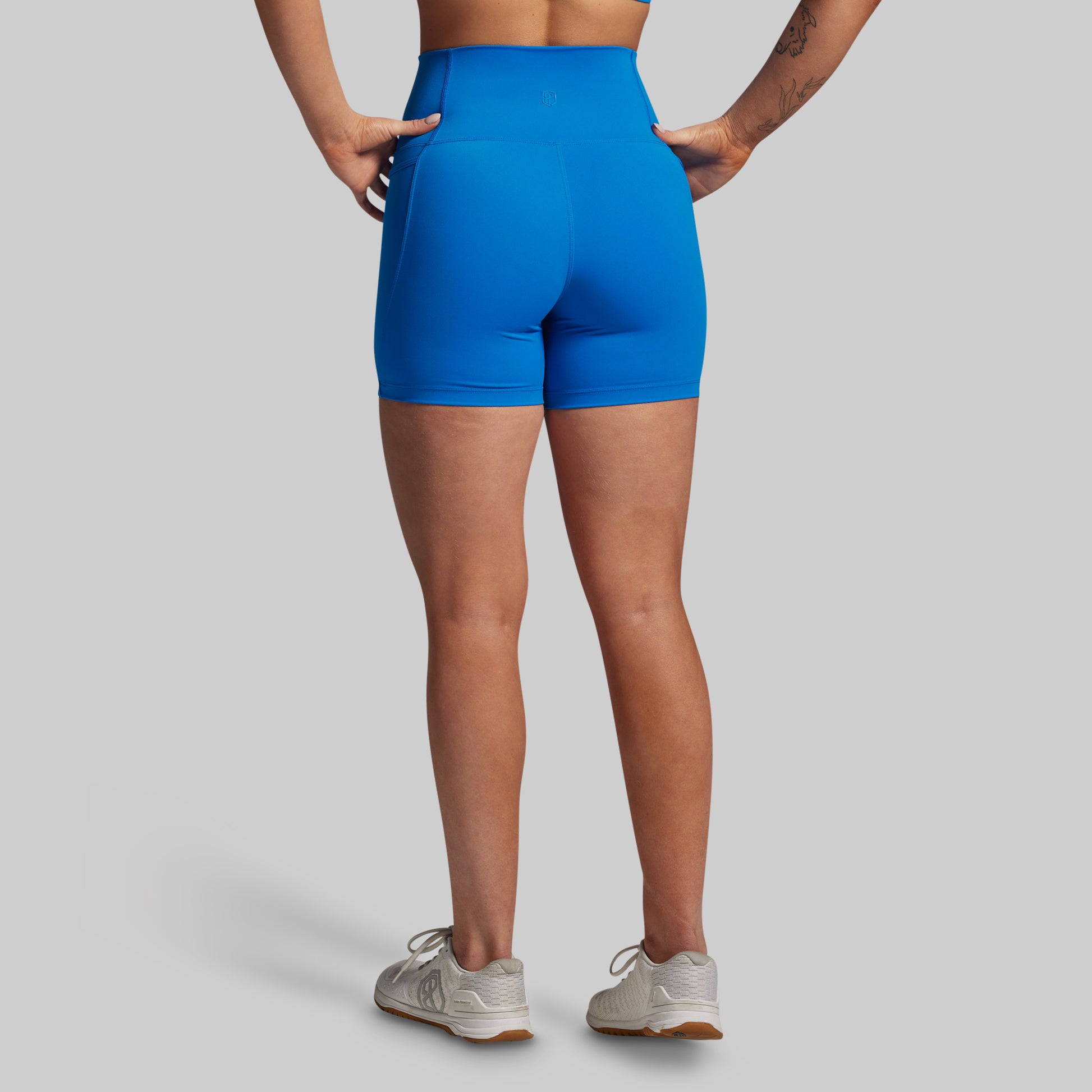 Person wearing blue athletic shorts on a gray background