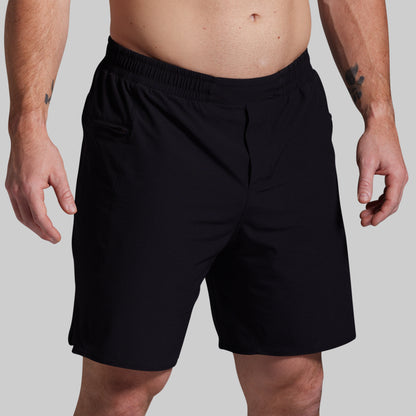 Black shorts worn by a person on a gray background