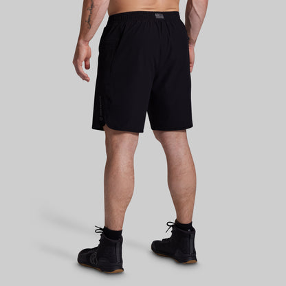 Person wearing black athletic shorts on a gray background
