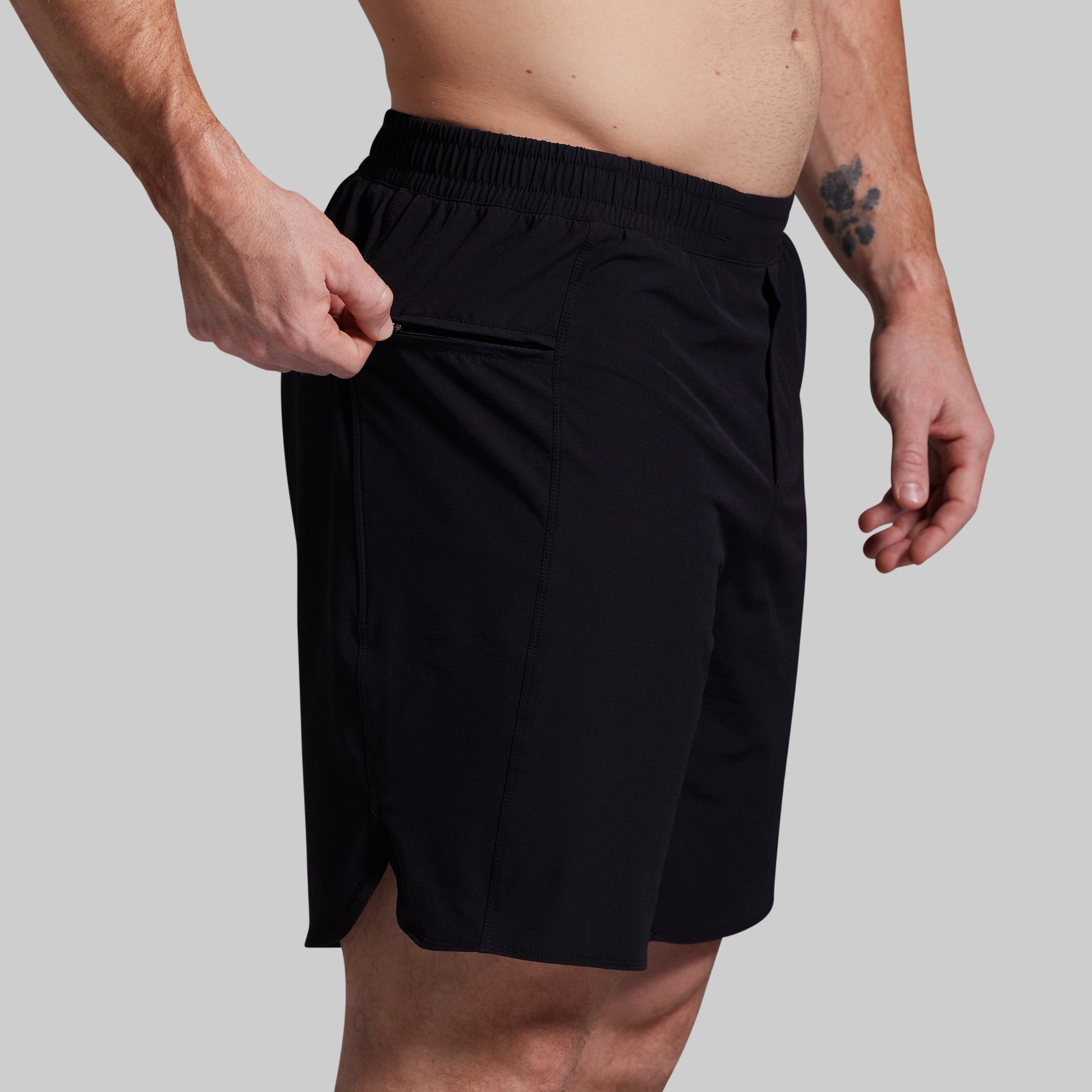 Black shorts worn by a person on a gray background