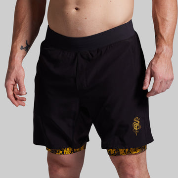 Black athletic shorts with a yellow logo on a gray background