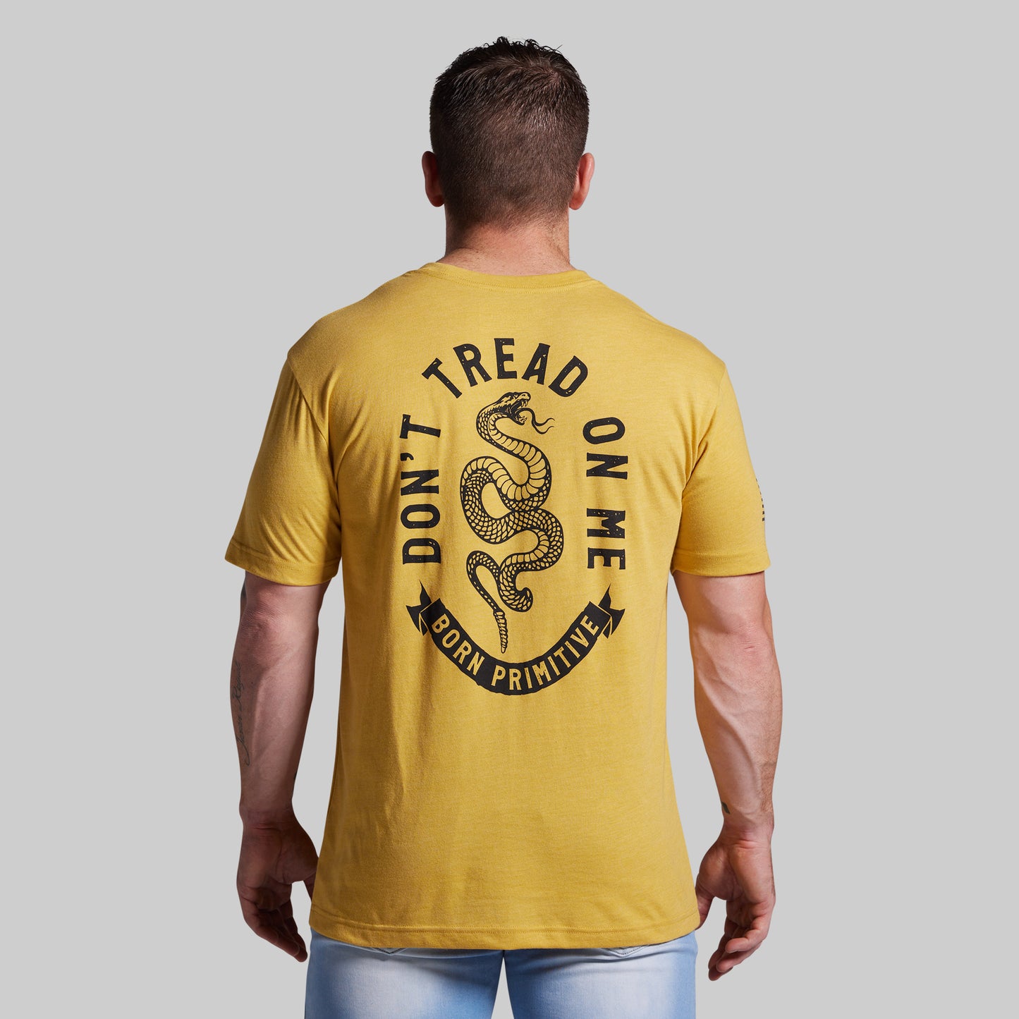 Man wearing a yellow t-shirt with 'Don't Tread on Me' graphic on the back.