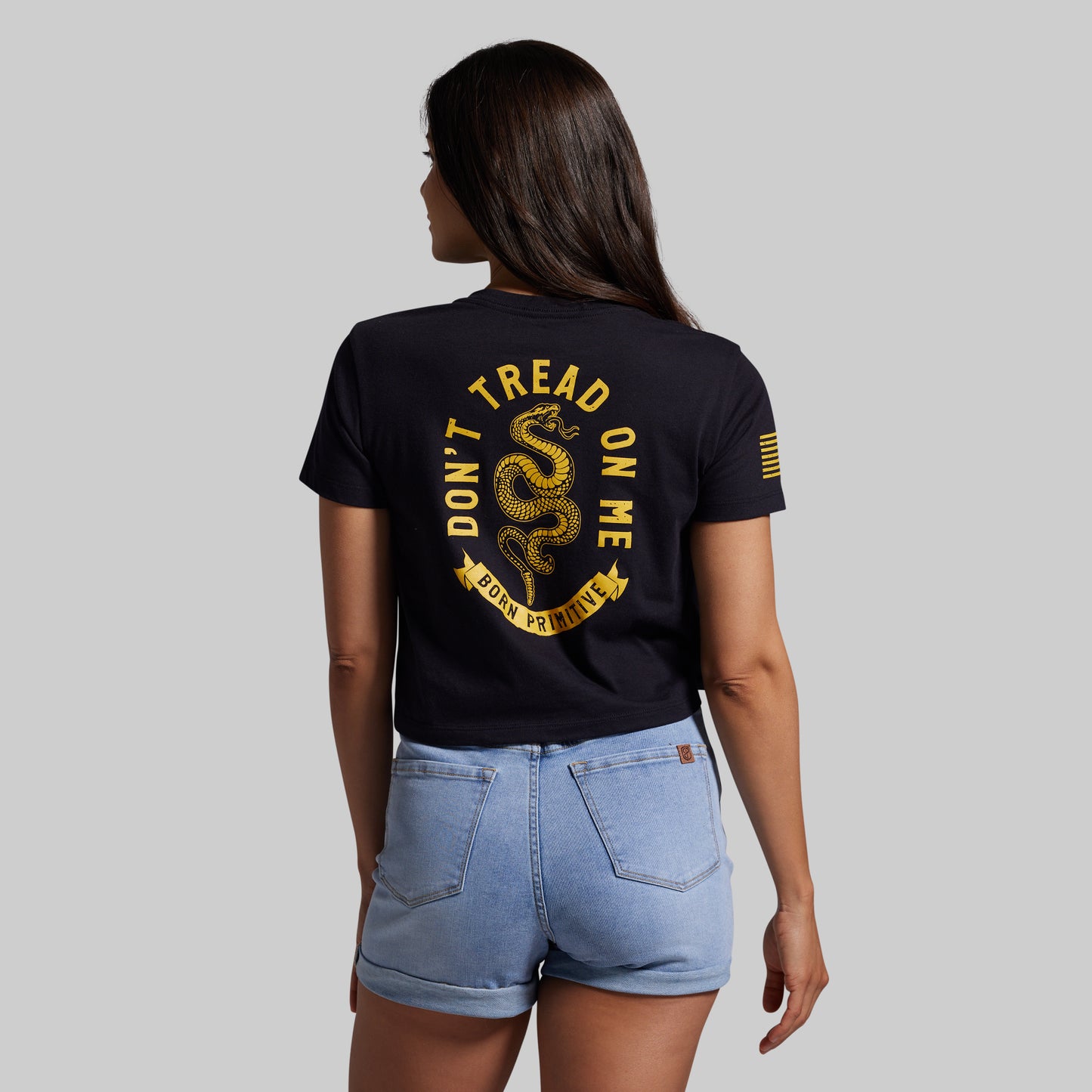 Person wearing a black t-shirt with 'Don't Tread on Me' design, standing against a plain background