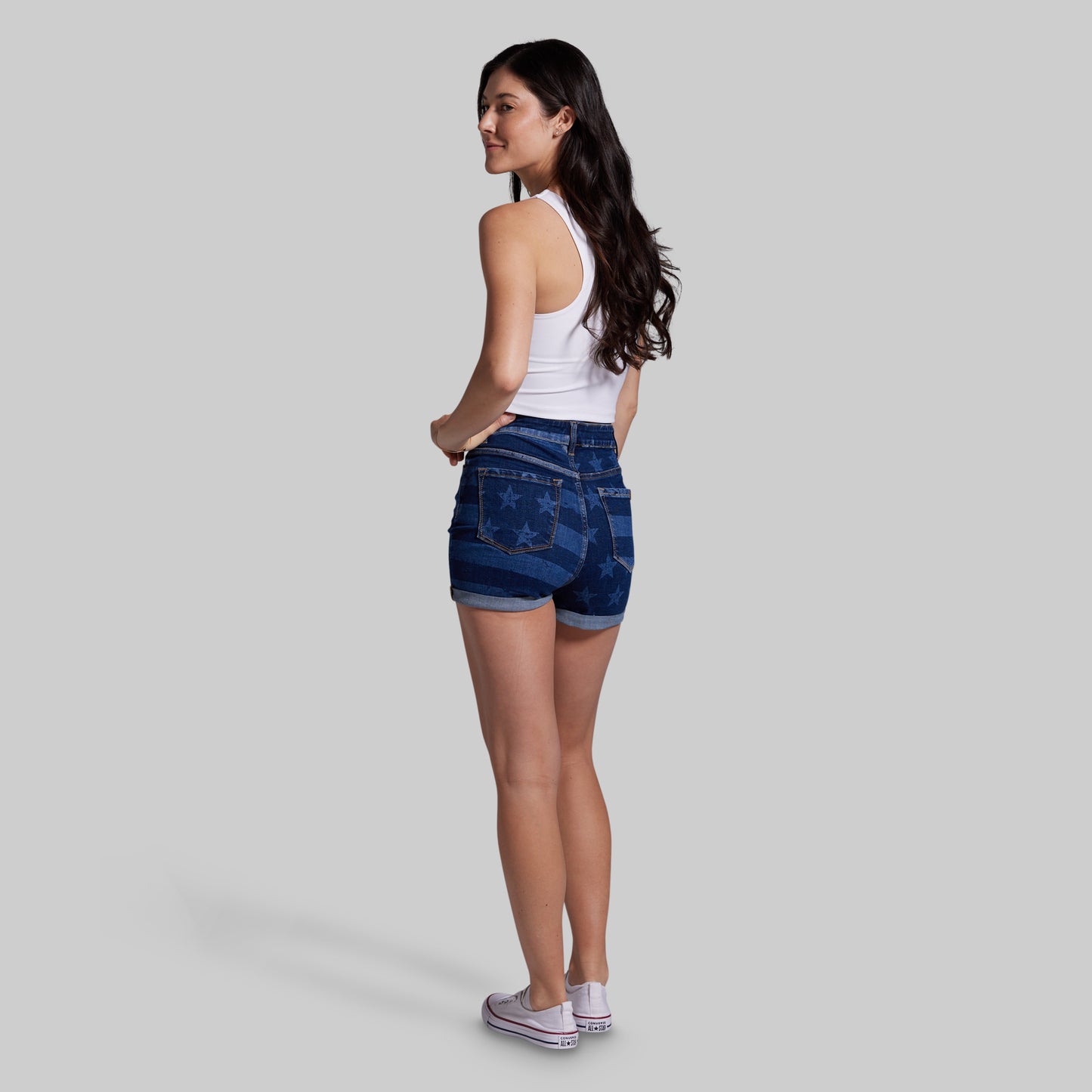 Woman wearing blue denim shorts on a gray background