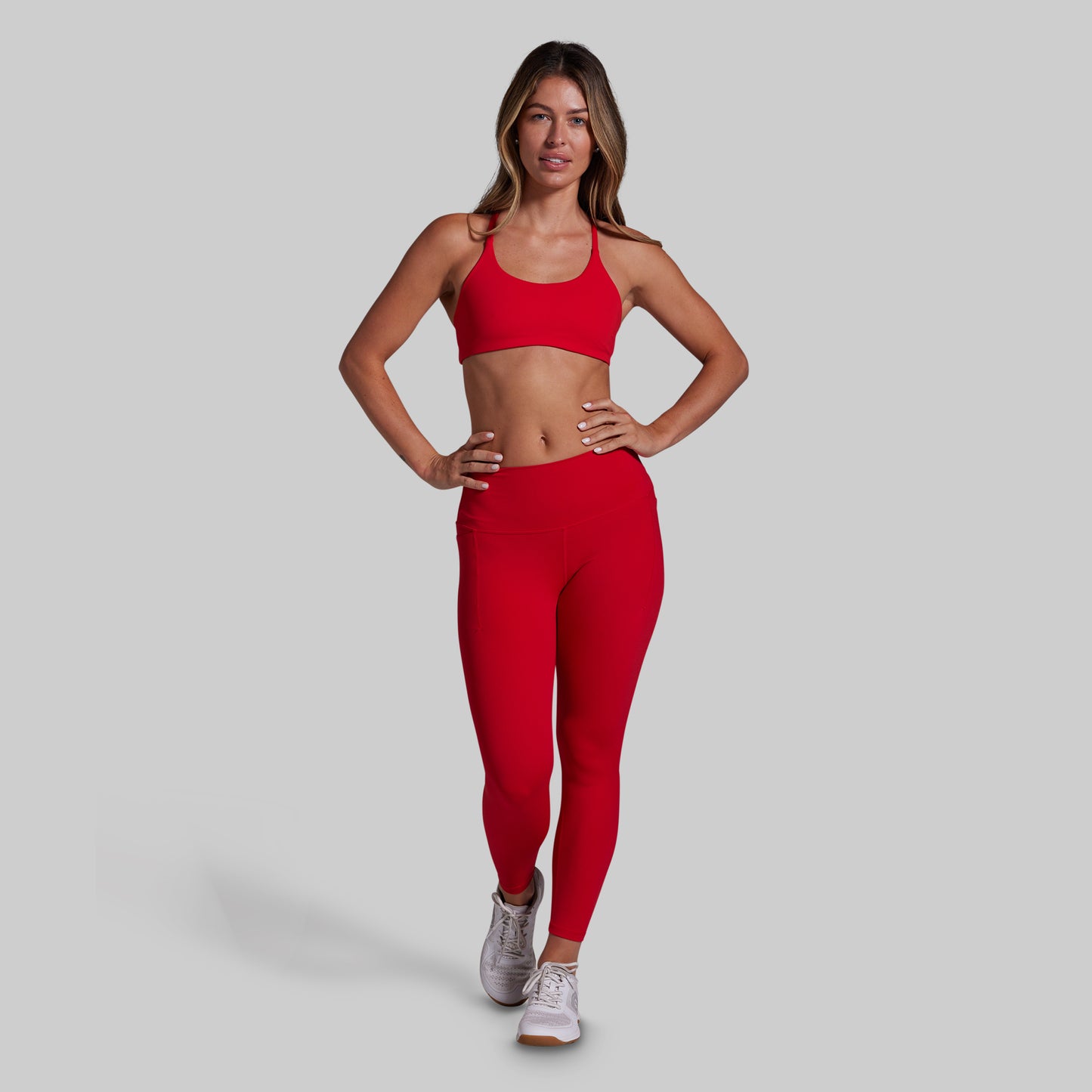 Woman wearing a red athletic outfit on a gray background