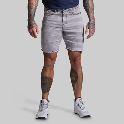 Person wearing light gray denim shorts on a plain background