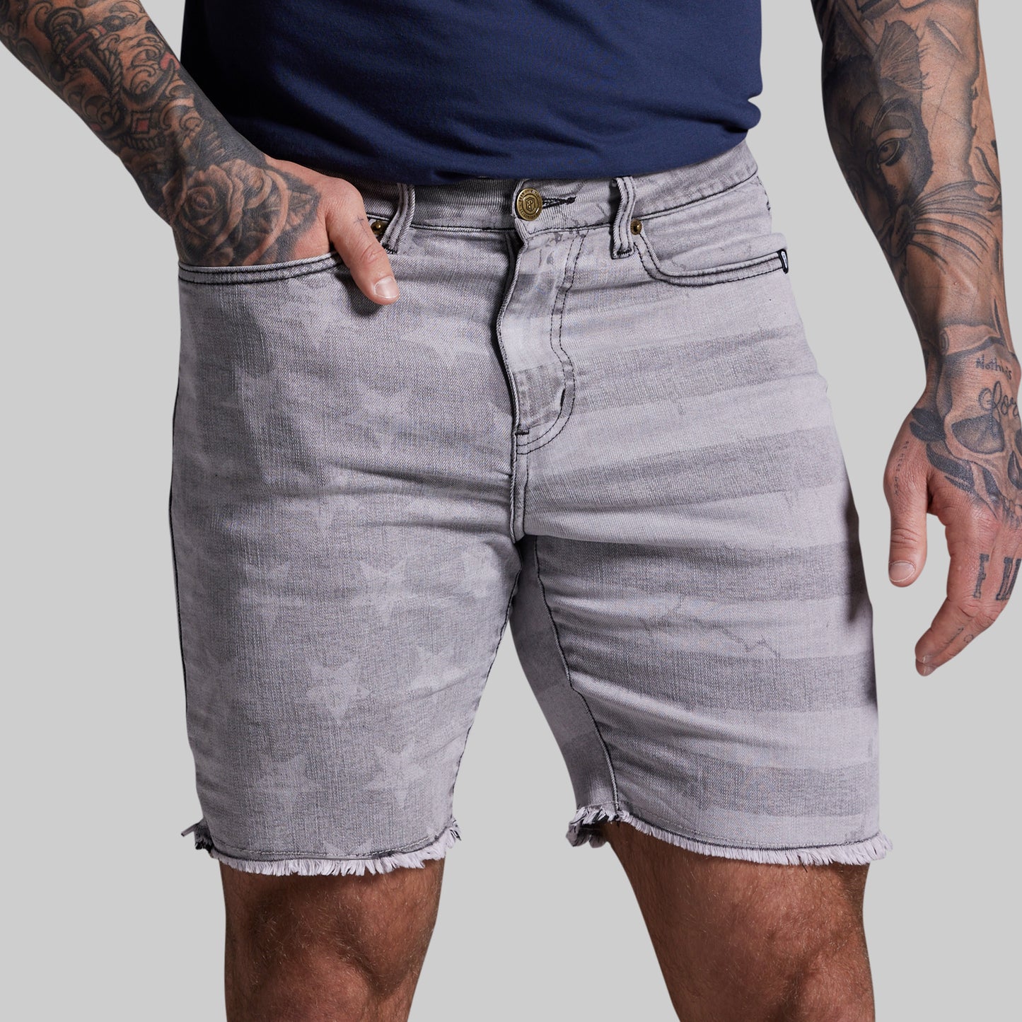 Person wearing gray denim shorts on a plain background