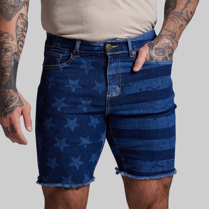 Blue denim shorts with star pattern worn by a person on a gray background