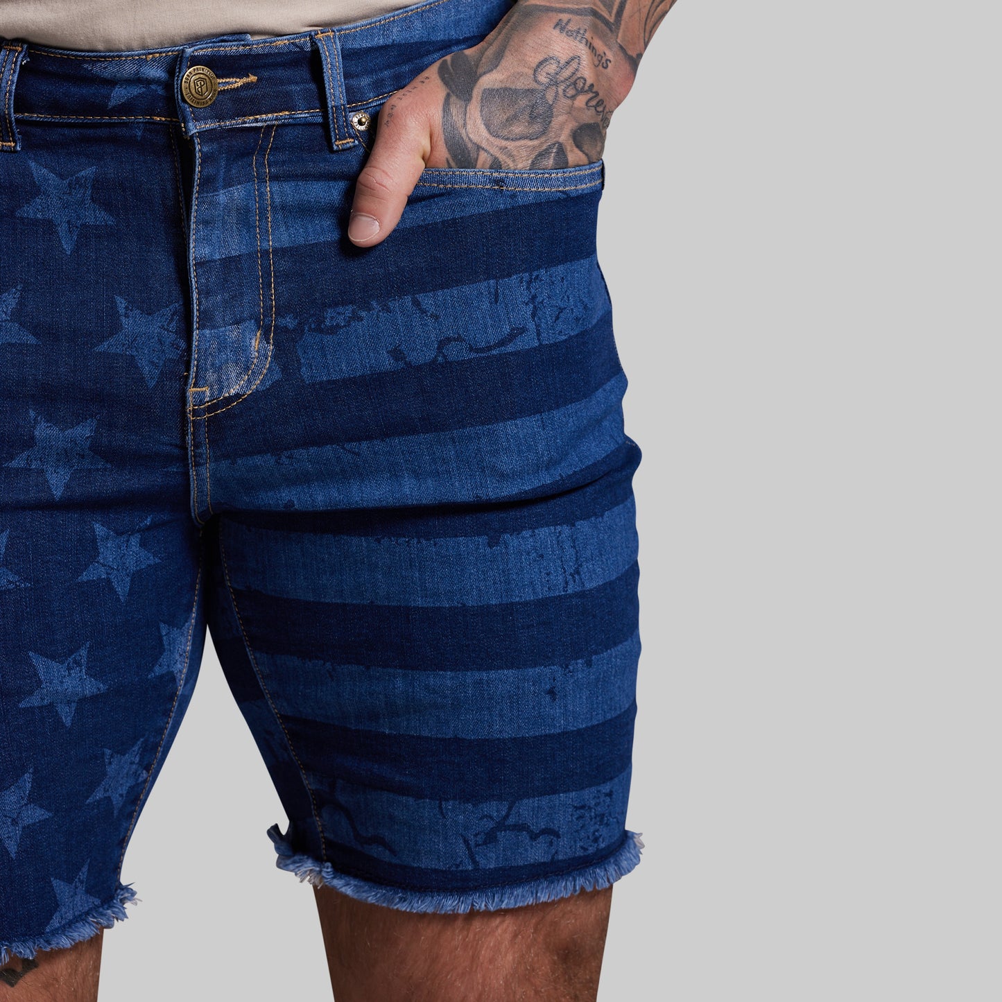 Blue denim shorts with star and stripe pattern on a gray background