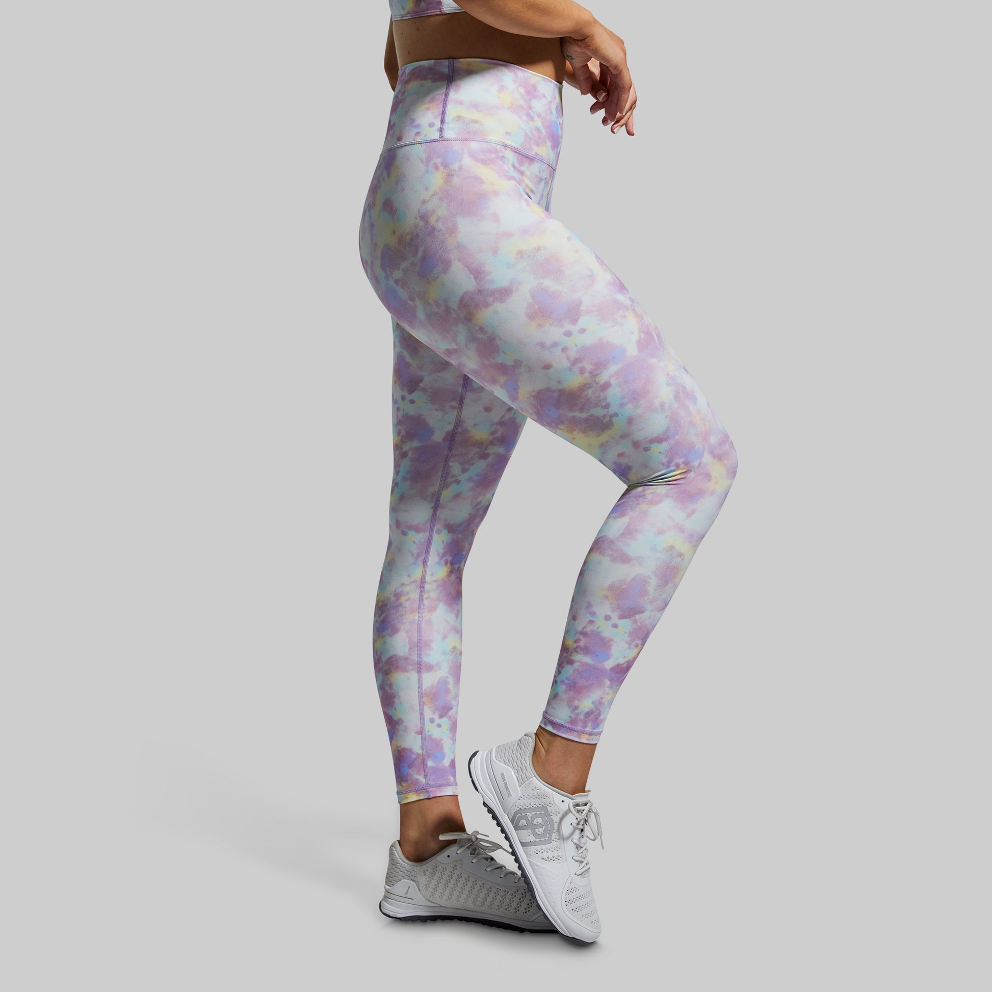 Person wearing colorful leggings on a gray background