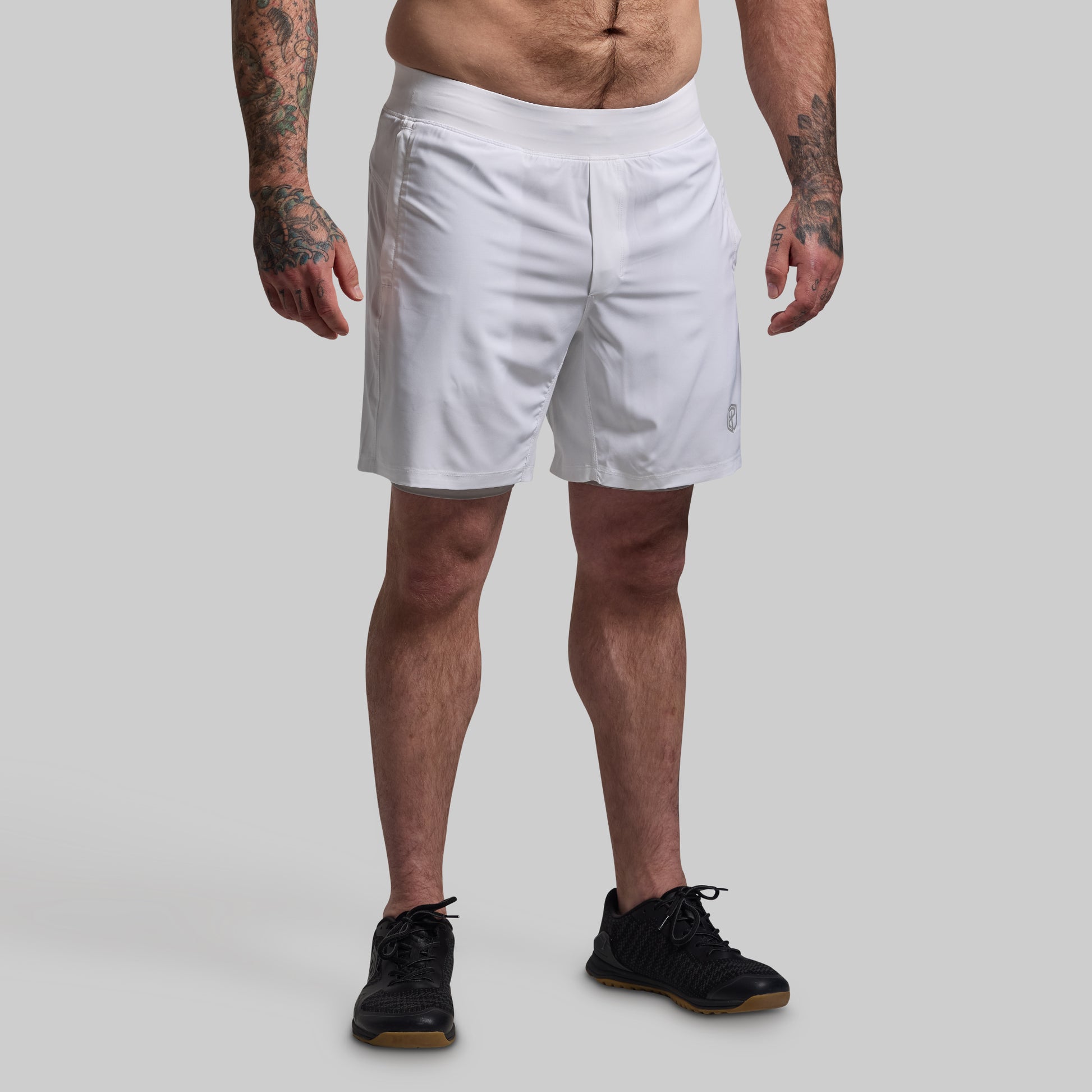 Person wearing white shorts on a plain background
