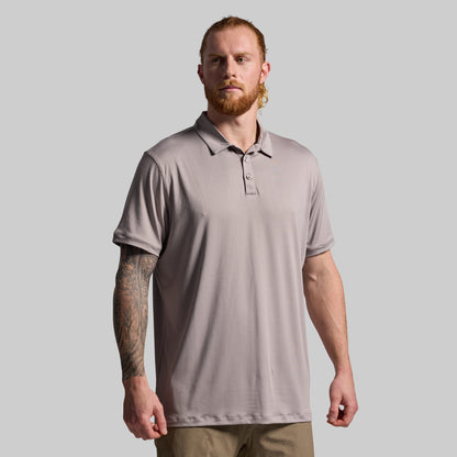 Man wearing a beige polo shirt against a plain background