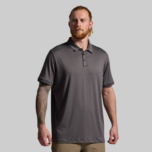 Man wearing a gray polo shirt against a plain background