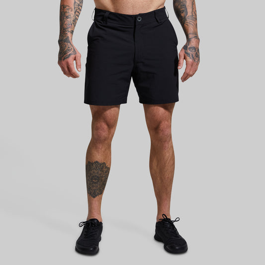 Person wearing black shorts on a gray background