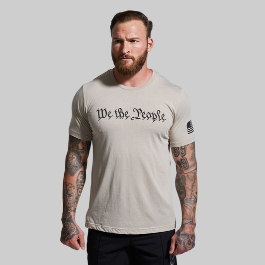 Man wearing a t-shirt with 'We the People' text on a plain background