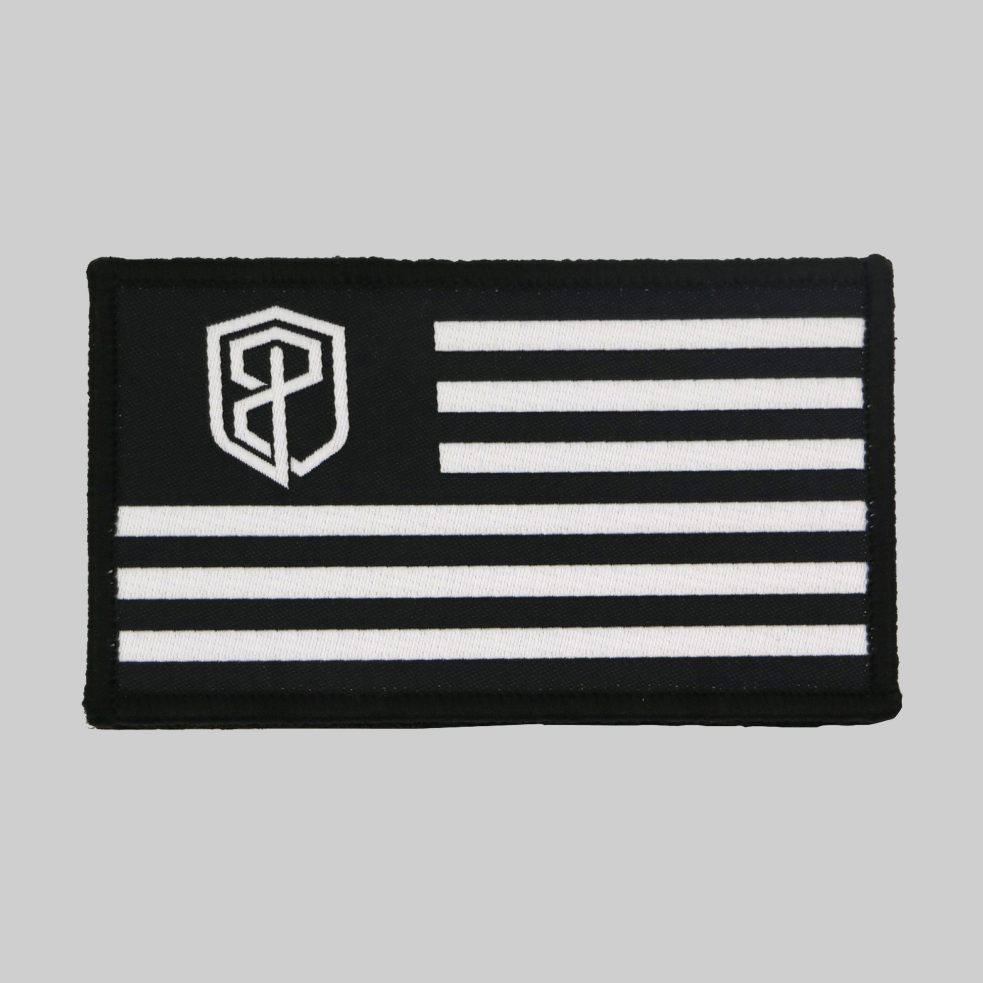 Black and white flag patch with a central emblem on a gray background