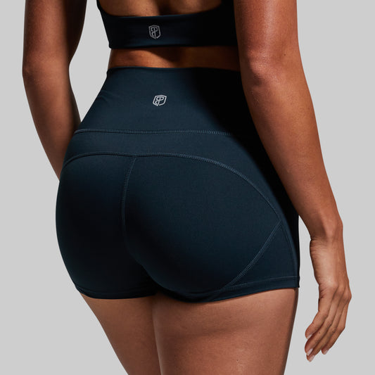 Person wearing dark green athletic shorts on a plain background