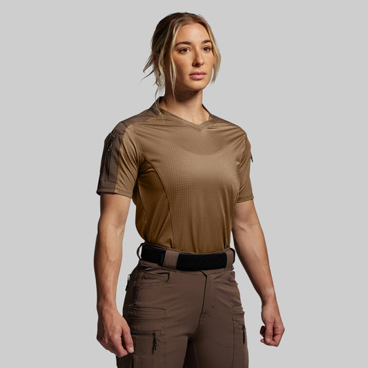 Person wearing a brown tactical outfit on a gray background
