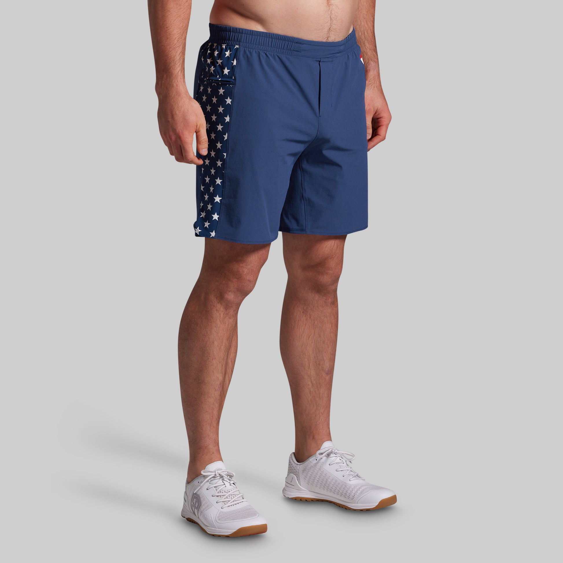 Person wearing blue athletic shorts with American flag design on a gray background