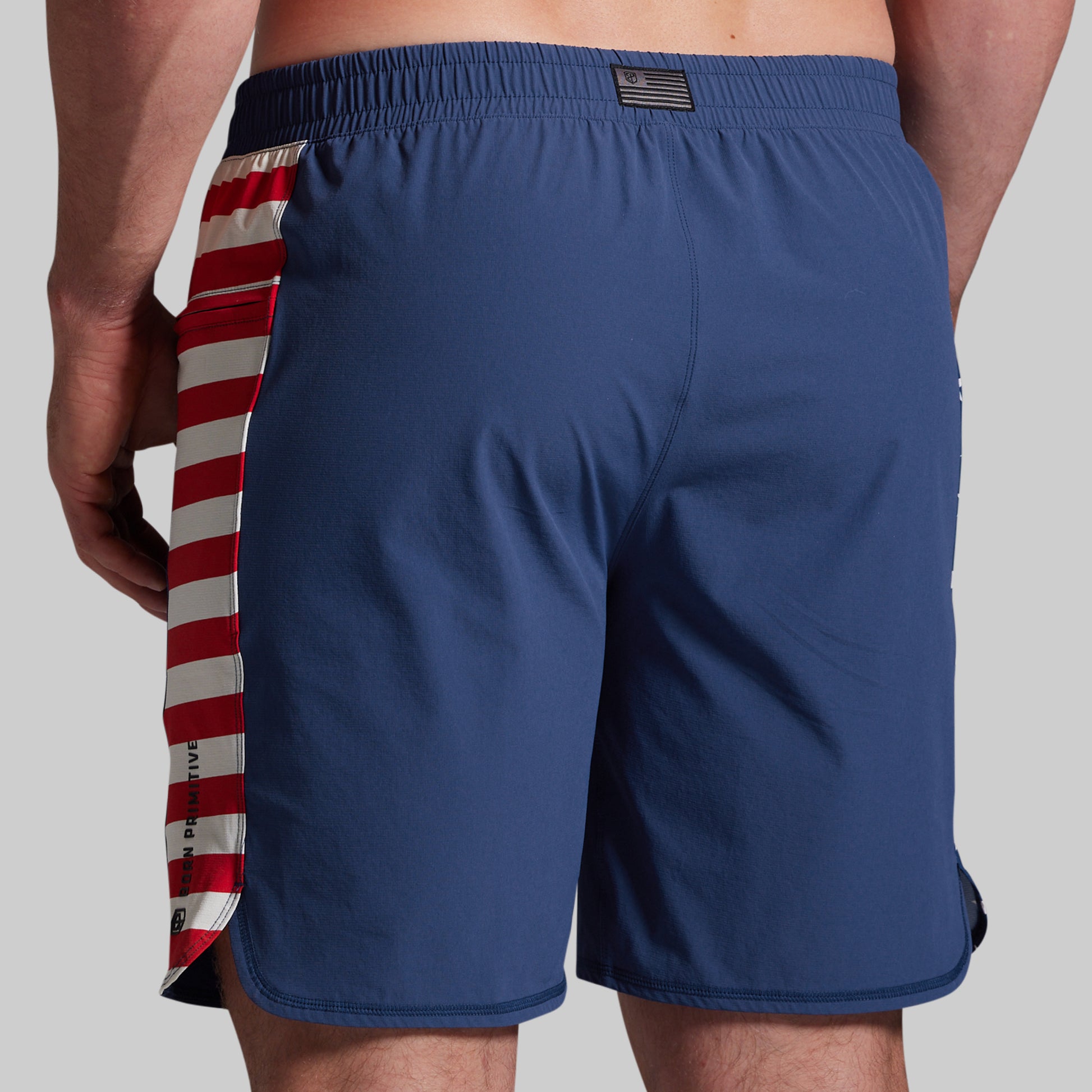 Blue shorts with a red and white striped side panel on a gray background