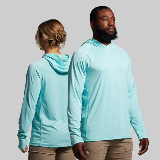 Two people wearing light blue hoodies against a gray background