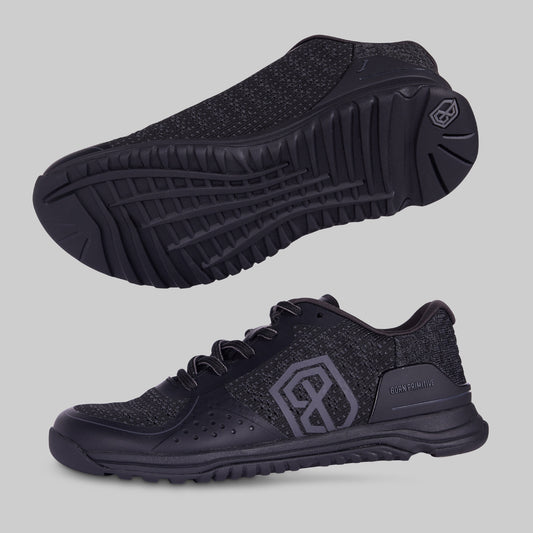 A pair of training shoes in black color, displayed from a side angle to showcase the sole and the upper part of the shoes.