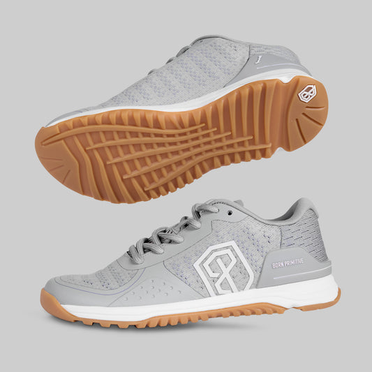 Gray athletic shoe with brown sole on a light gray background