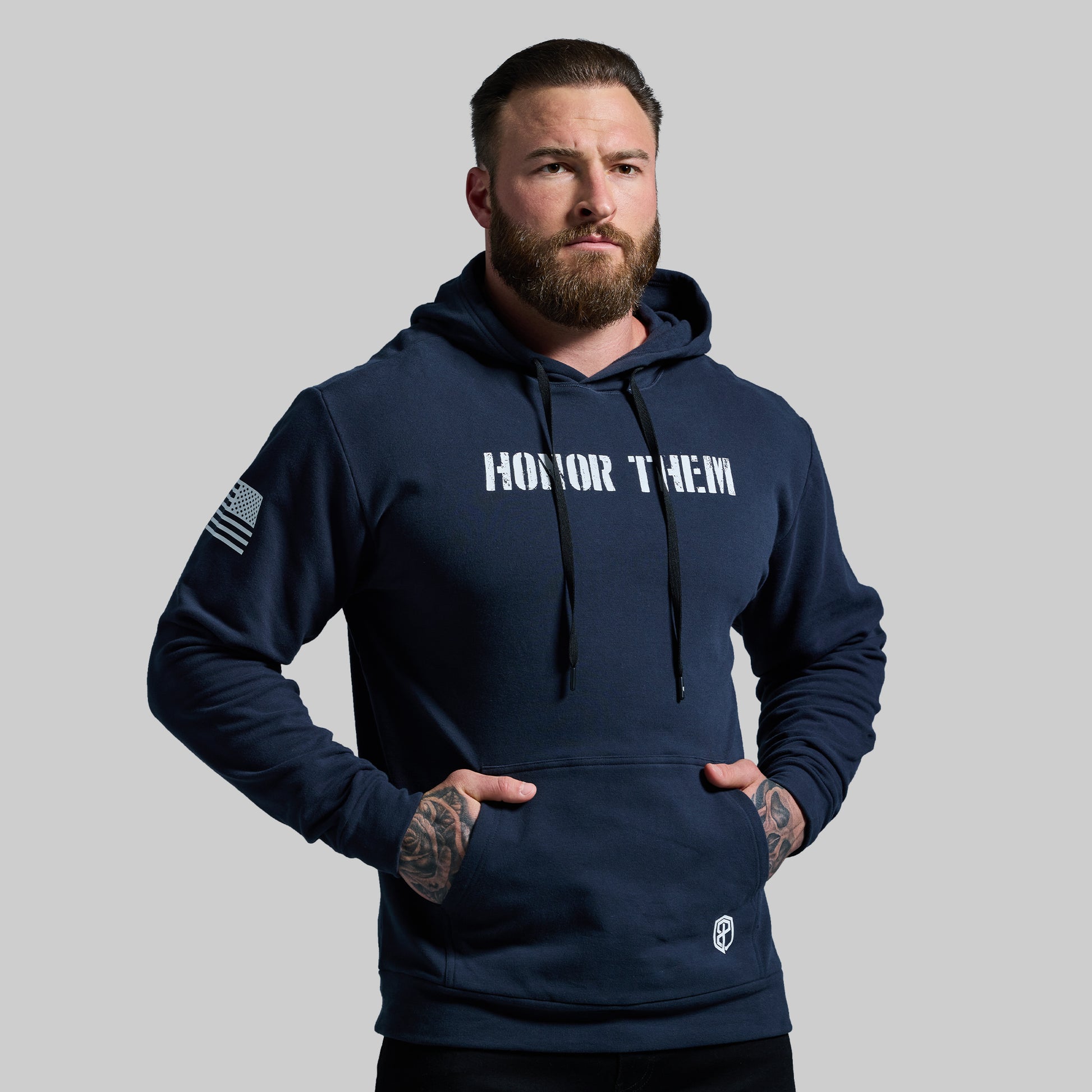 Man wearing a navy hoodie with 'Honor Them' text on a gray background