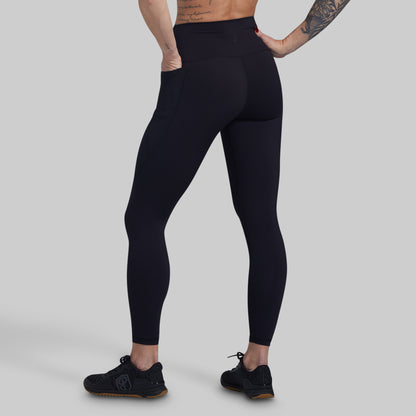 Person wearing black leggings on a gray background