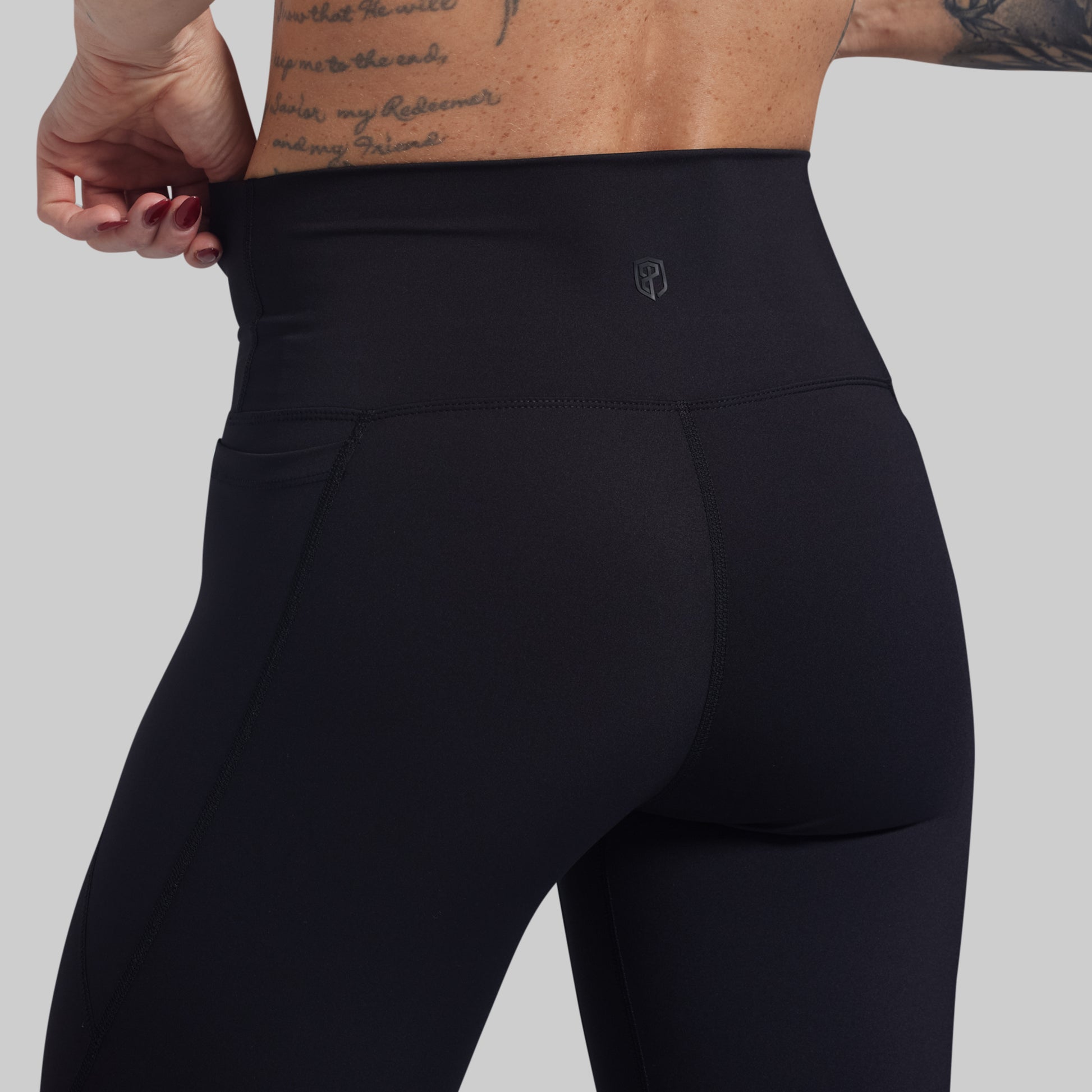 Black leggings worn by a person on a gray background