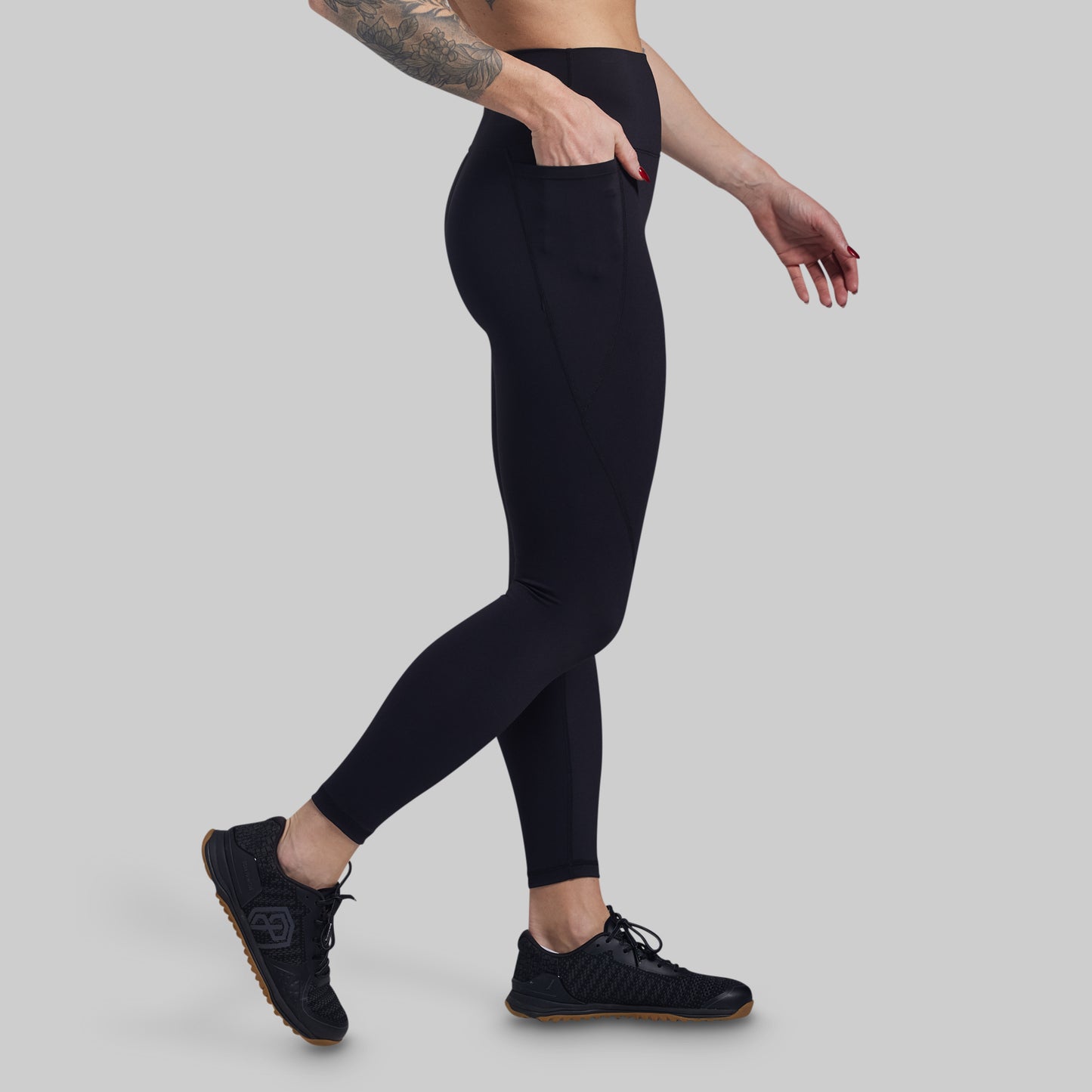 Person wearing black leggings on a gray background