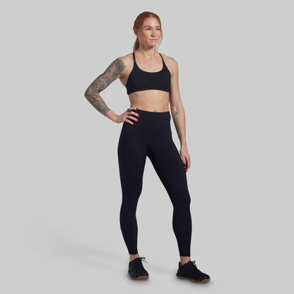 Woman wearing black athletic wear on a gray background