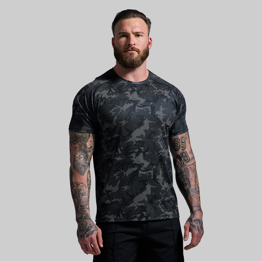 Man wearing a black camouflage t-shirt on a gray background
