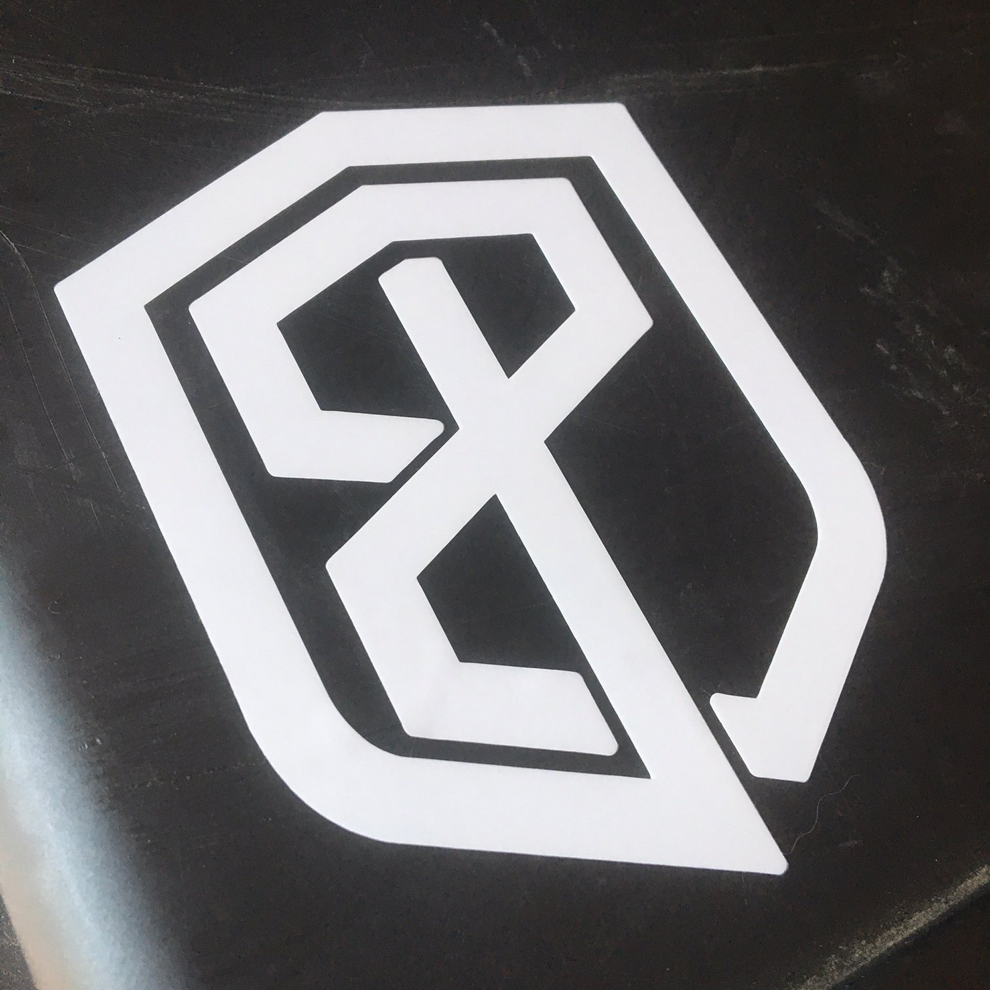White sticker logo on a black surface
