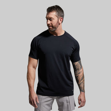 A man wearing a black short-sleeved crew neck t-shirt.