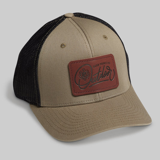 Beige and black cap with a brown leather patch on a gray background