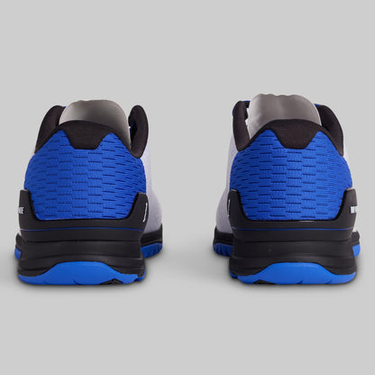 Pair of sneakers with blue soles on a gray background