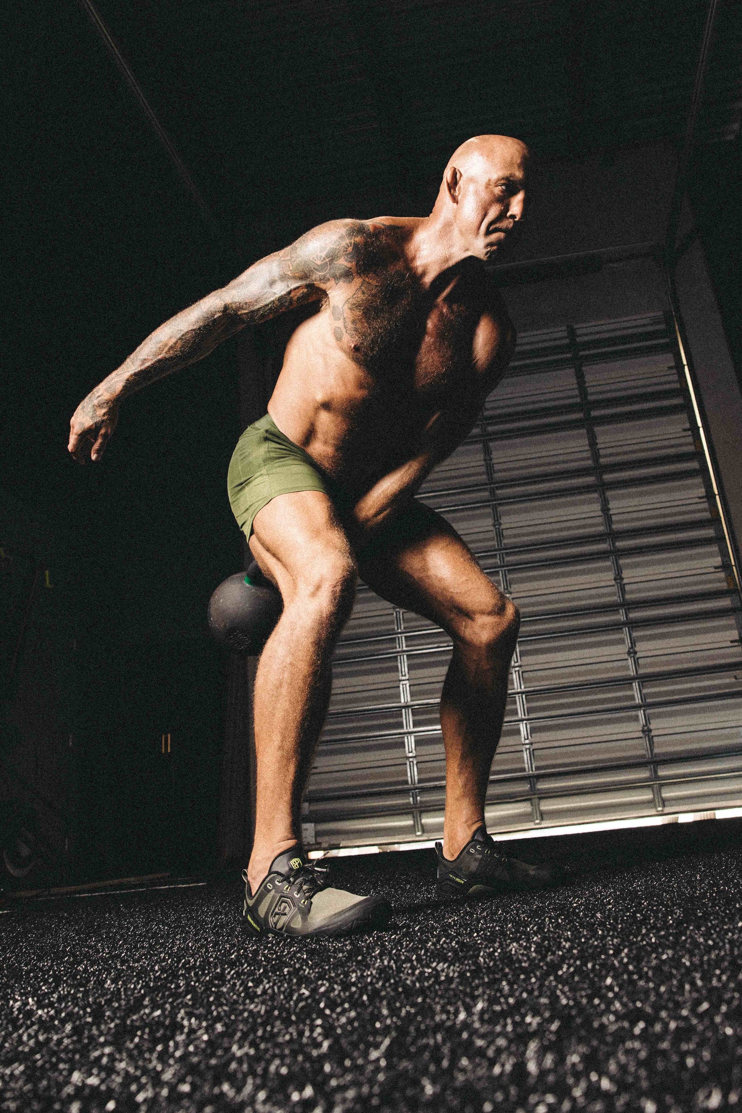 Barefoot athlete doing kettlebell swing
